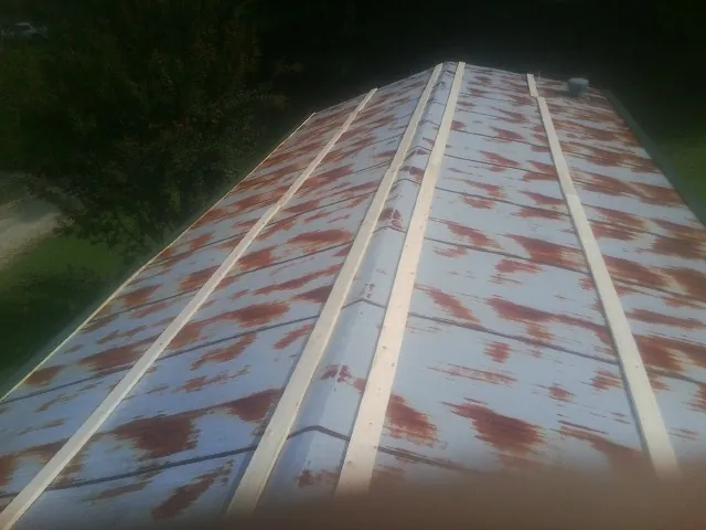 Rusted metal roof panels with new wood purlins before replacement — Storm Damage Roof Repair in Masonville by Roofing Brothers